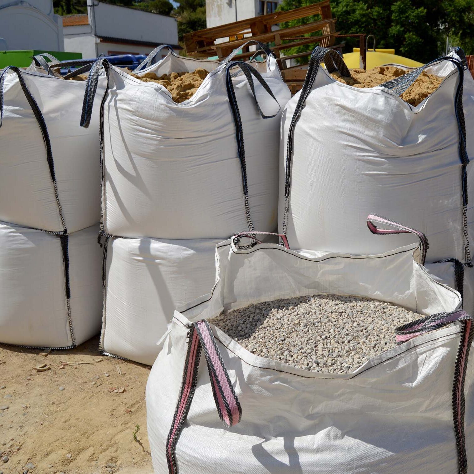 Large sacks of aggregates for making concrete mixes. Building materials for architecture. Large raffia sacks filled with aggregates to make concrete mixes. Bags of sand and gravel in a building materials warehouse
