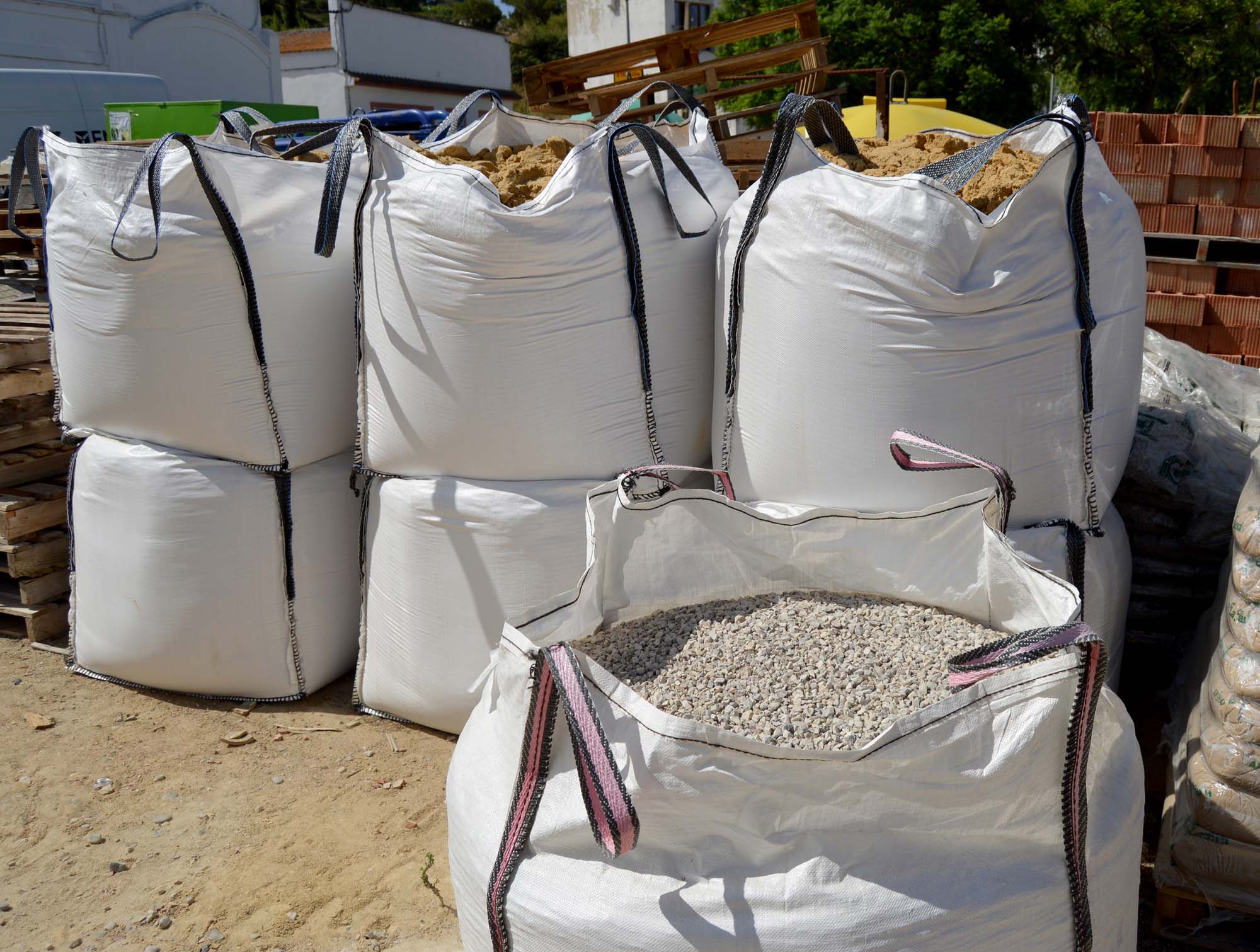 Large sacks of aggregates for making concrete mixes. Building materials for architecture. Large raffia sacks filled with aggregates to make concrete mixes. Bags of sand and gravel in a building materials warehouse